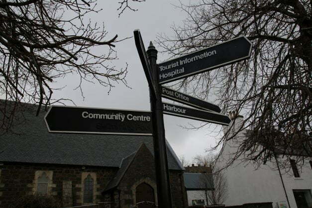 Information sign in Portree pointing to places of interest in the town; Community Centre, Tourist information, Hospital, Post Office, Harbour.